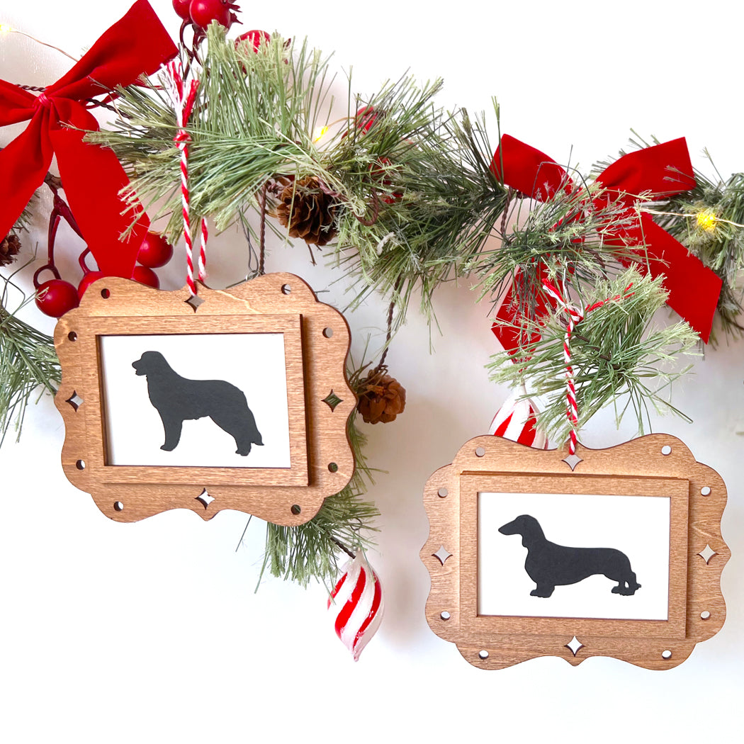 Wooden frames with dog silhouettes on a Christmas-themed background with garlands and ribbons.