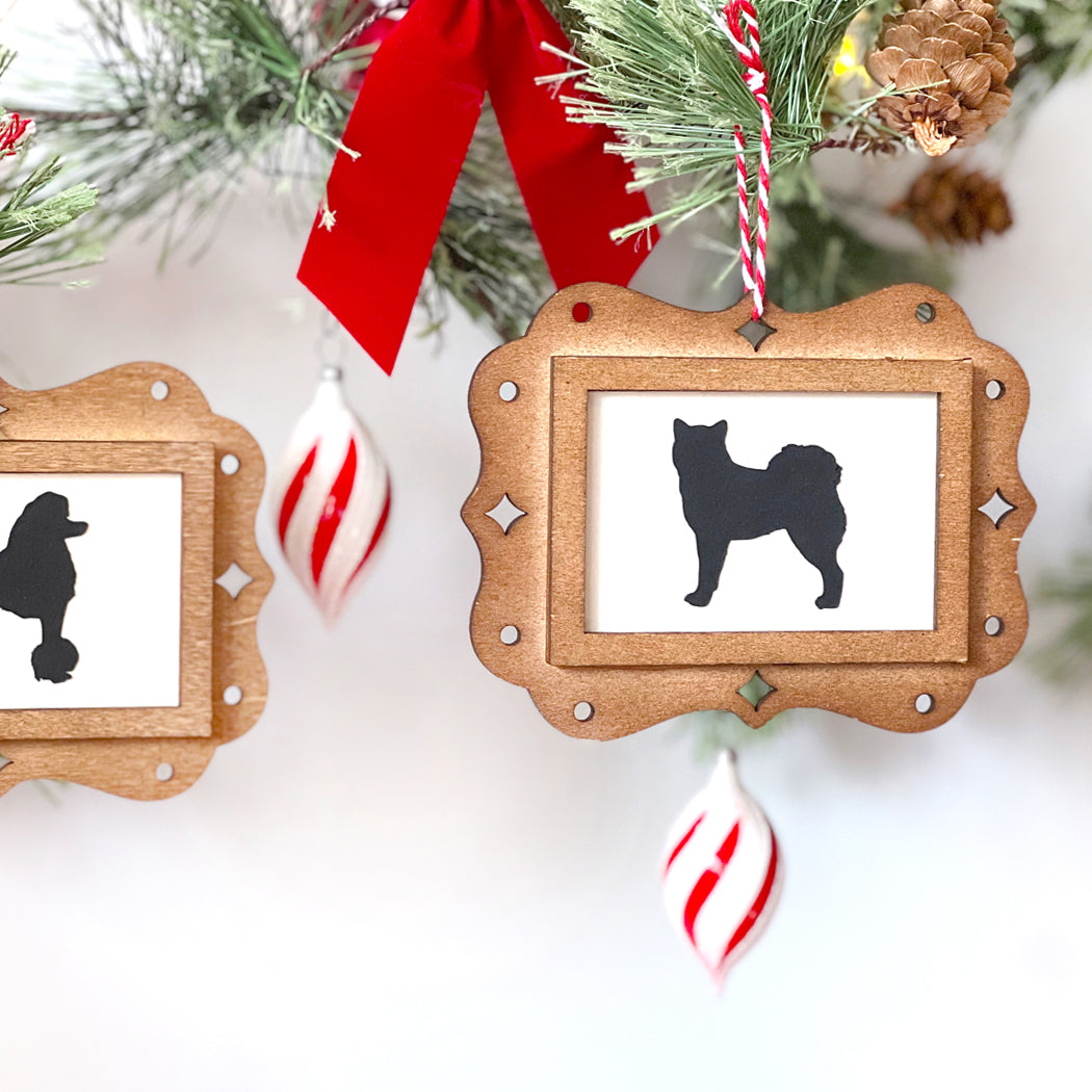 Wooden Christmas ornament with dog silhouette on a white background