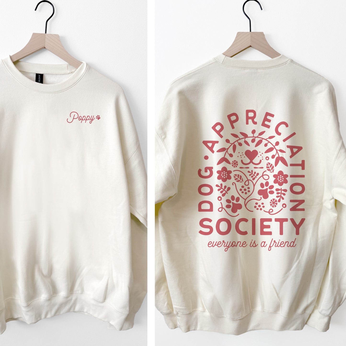 Off white sweatshirt with pink text and graphics on a white background