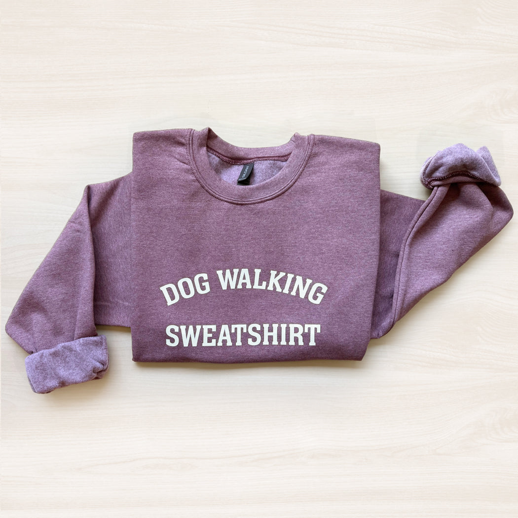 Maroon sweatshirt with 'DOG WALKING SWEATSHIRT' text on a light background