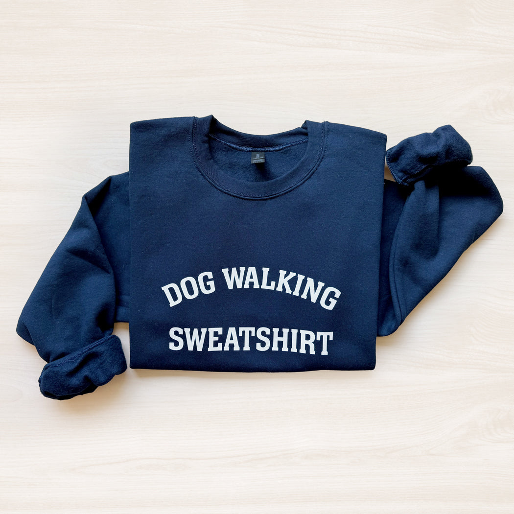 Navy blue sweatshirt with 'DOG WALKING SWEATSHIRT' text on a light background