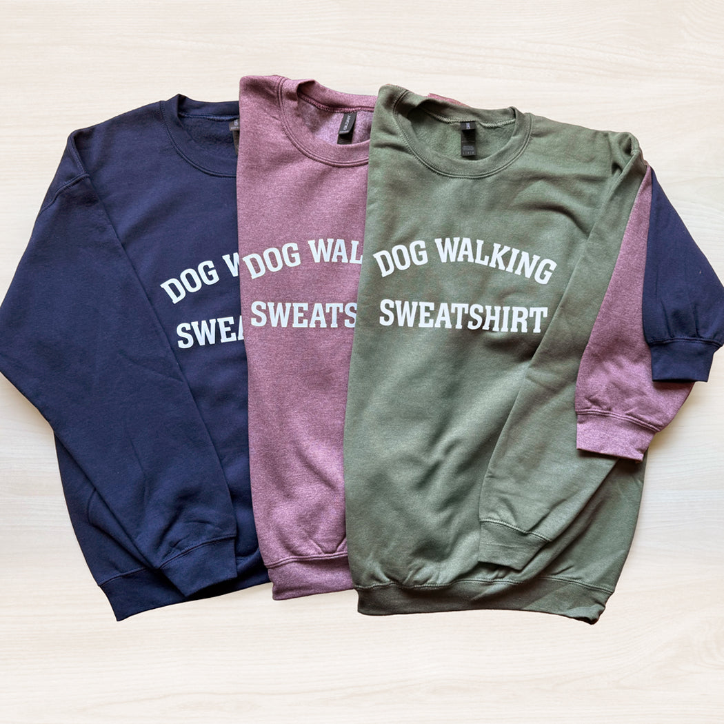 Three sweatshirts in navy, maroon, and green with 'DOG WALKING SWEATSHIRT' text on a light background.