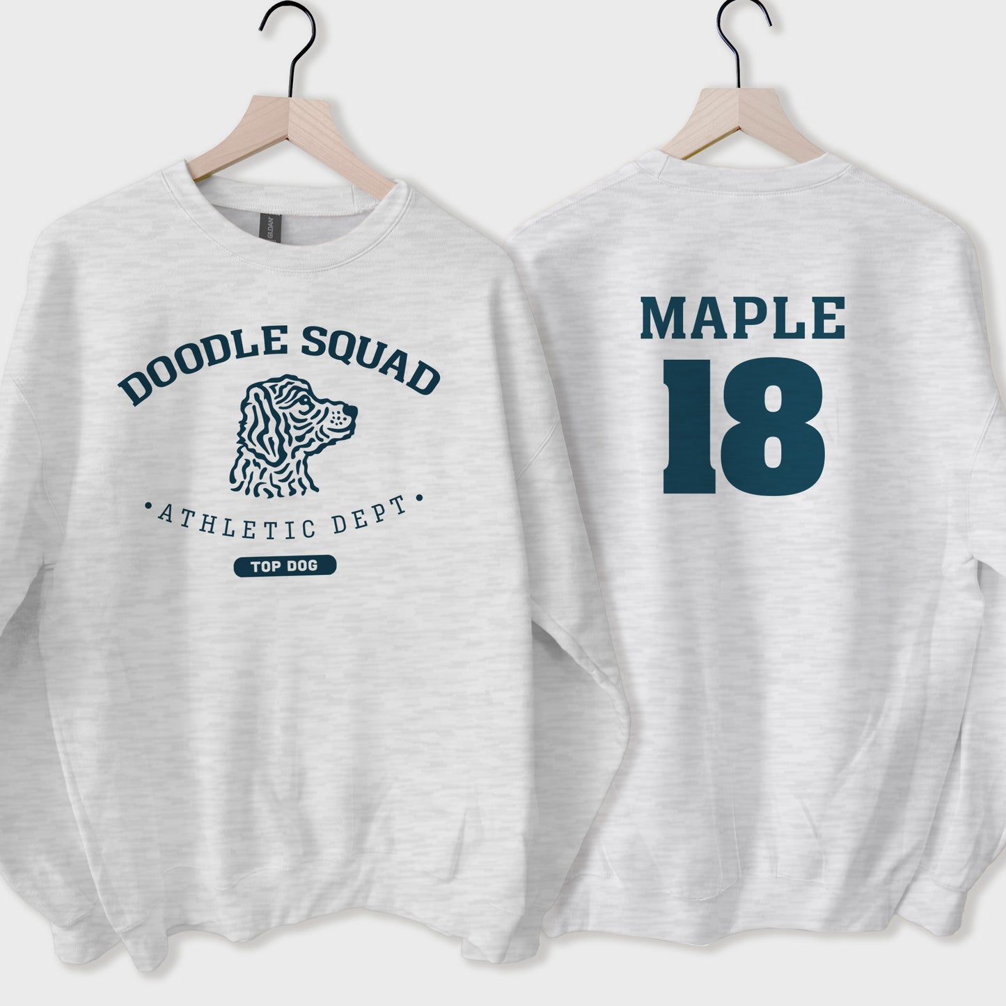 Two light gray sweatshirts with 'Doodle Squad' and 'Maple 18' text on hangers.
