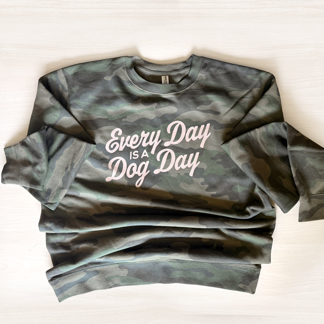 Every Day Is a Dog Day crewneck sweatshirt in Forest Camo with retro tan lettering. Flatlay on a light tan background.