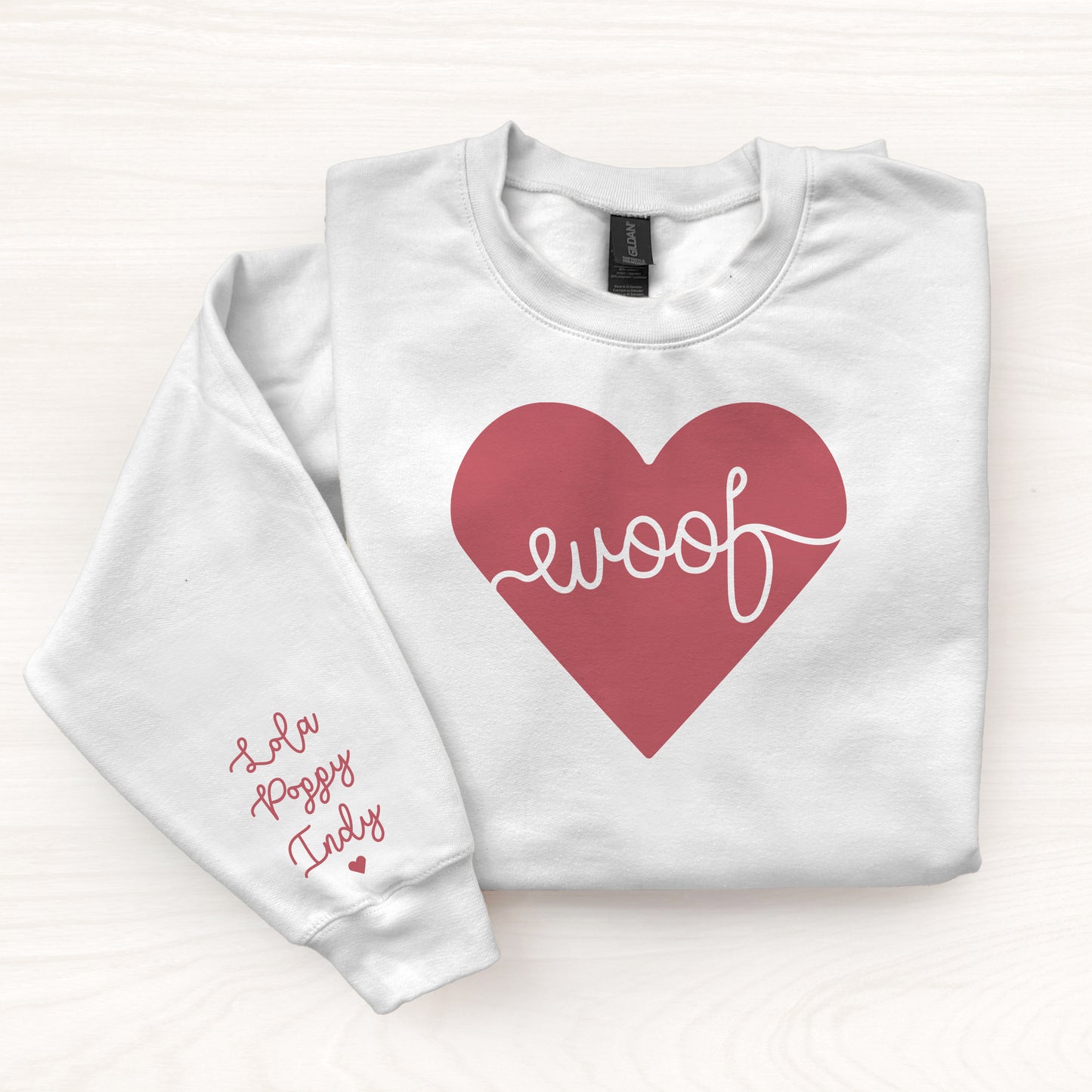 White sweatshirt with a red heart and 'woof' text on a white background
