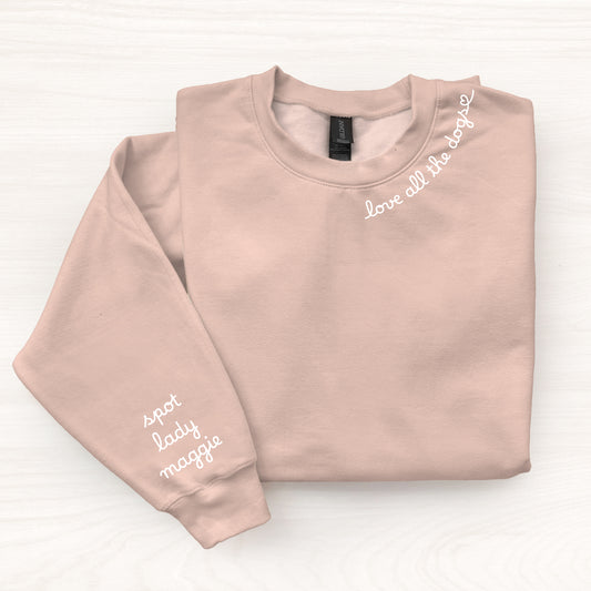 Folded blush pink sweatshirt with text on a white background