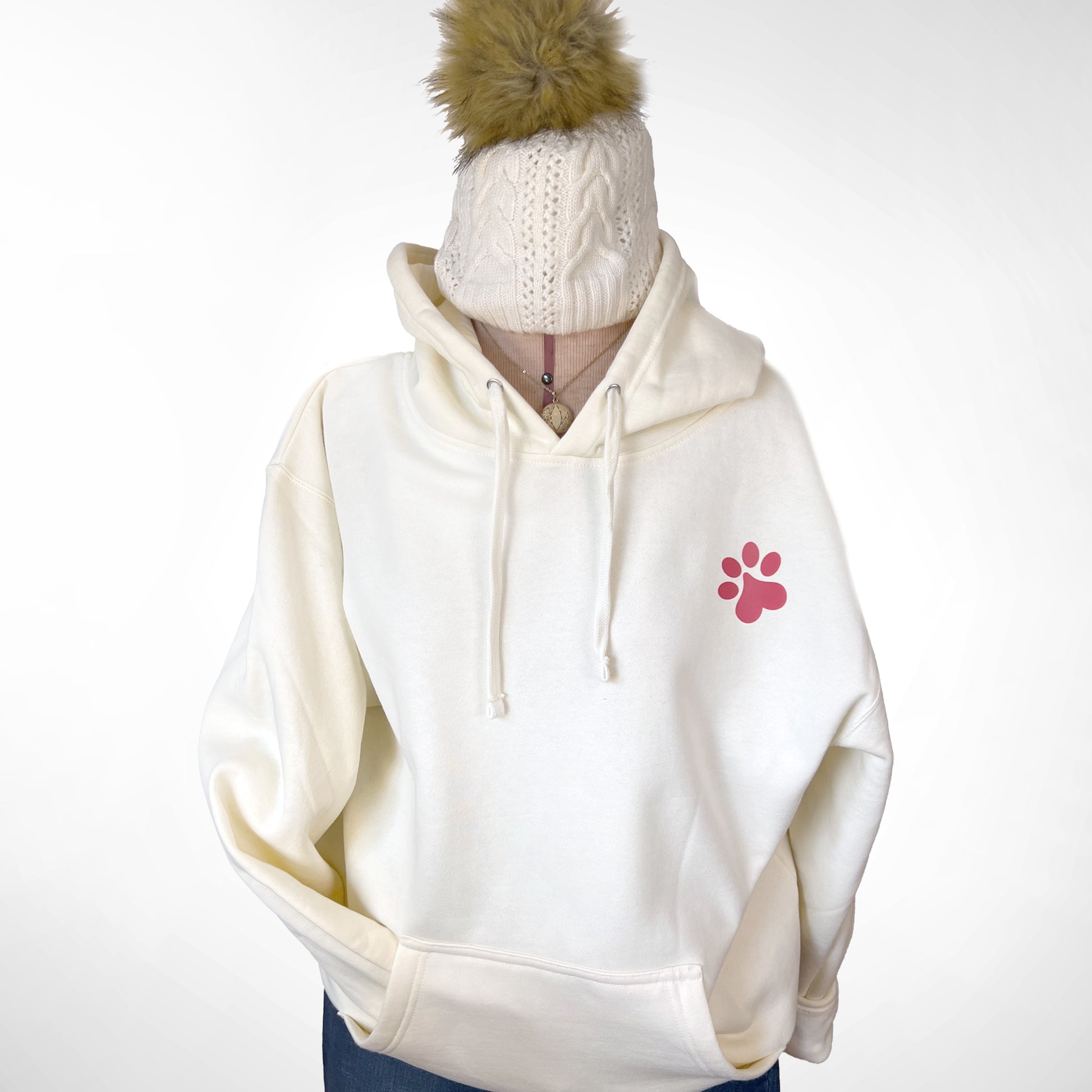 Front view of bone-colored hoodie with paw print design.
