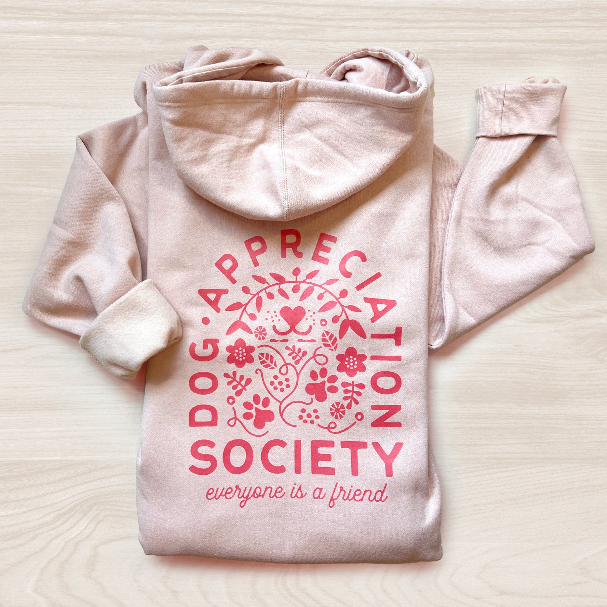 Back view of dusty pink Dog Appreciation Society Hoodie with hand-illustrated design.