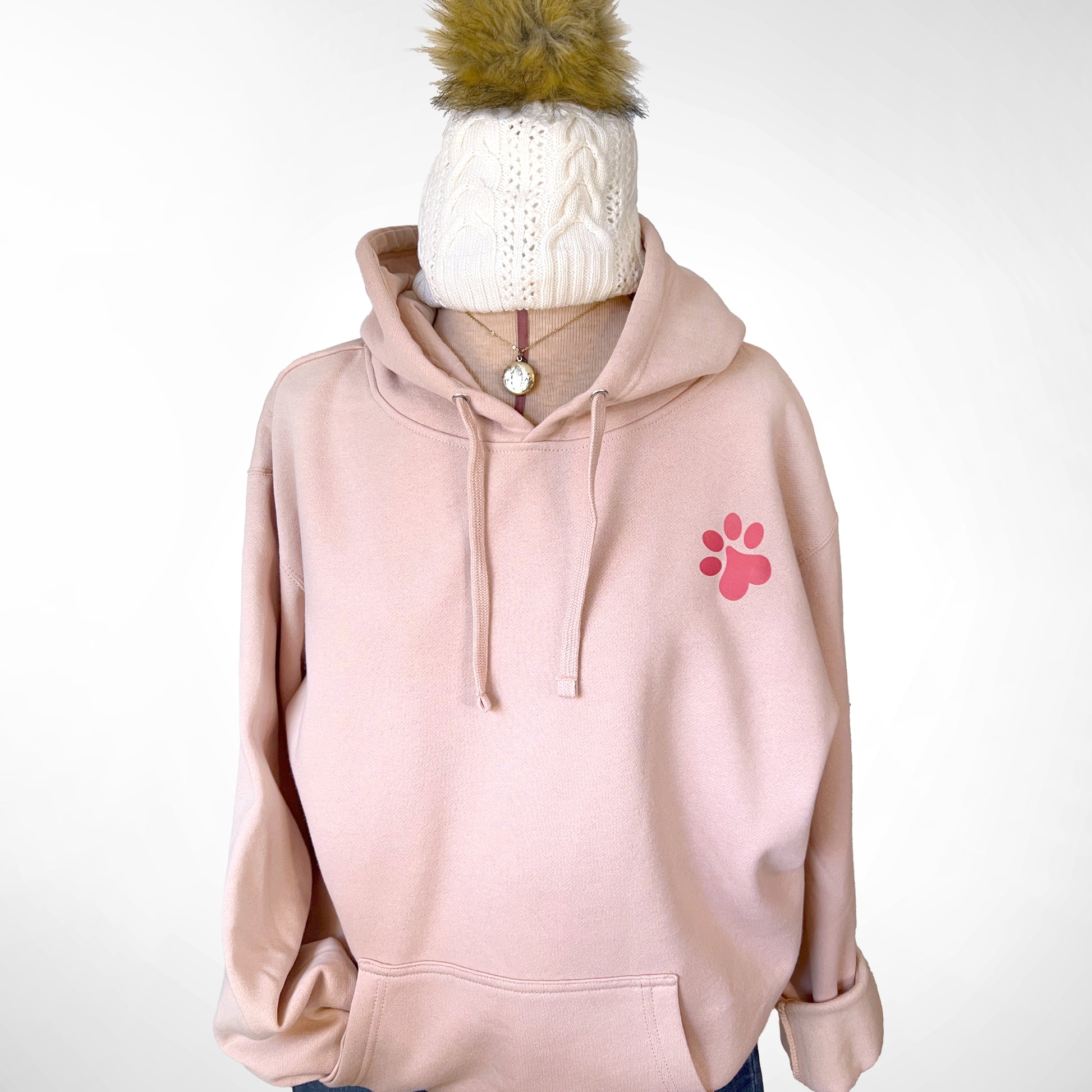 Front view of dusty pink-colored hoodie with paw print design.