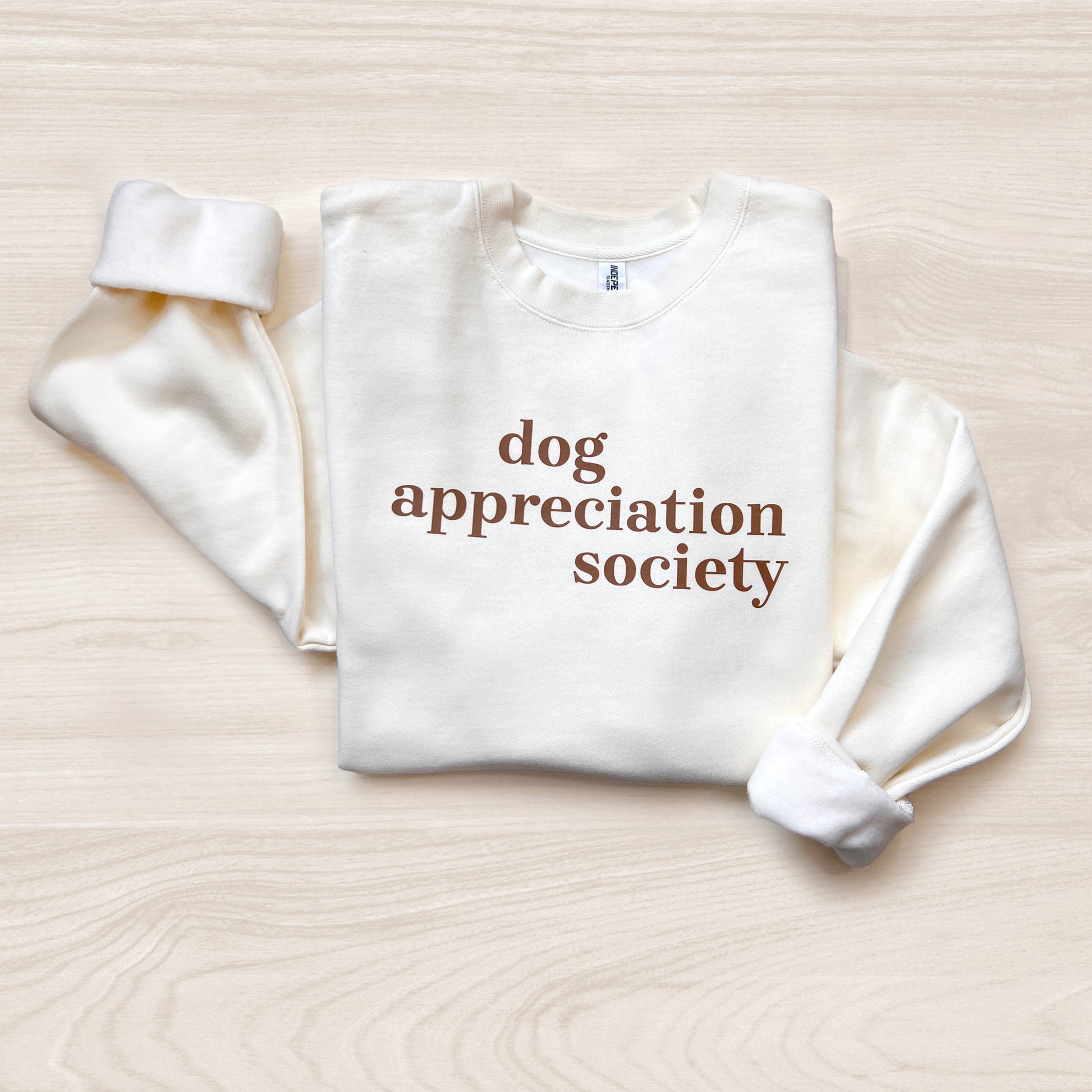 Front view of Dog Appreciation Society Sweatshirt in Bone color with brown typography.