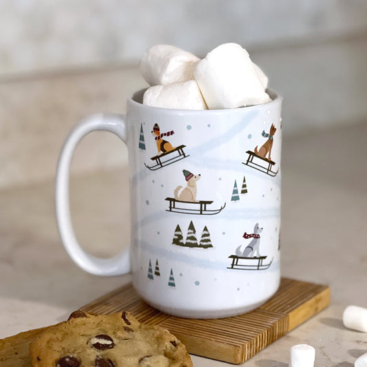 Front view of Dog Sledding Winter Mug featuring illustrated dogs sledding through a snowy landscape.
