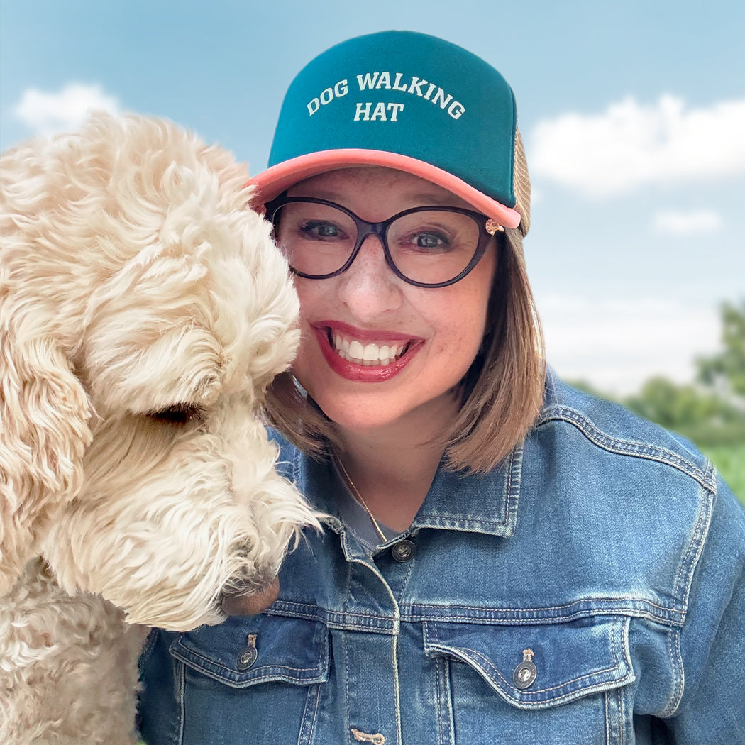Dog lover wearing a breathable mesh back trucker hat while walking a dog outdoors
