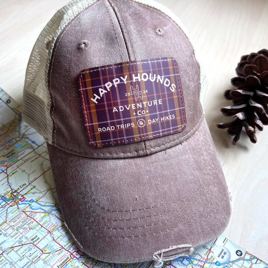 Happy Hounds distressed trucker hat with embroidered patch and mesh back.