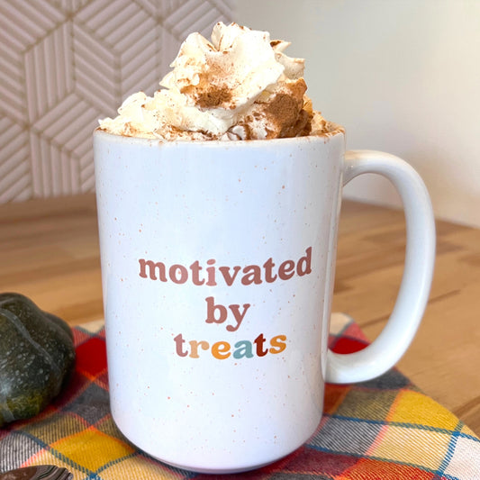 White ceramic mug with ‘Motivated by Treats’ text – perfect gift for dog owners.