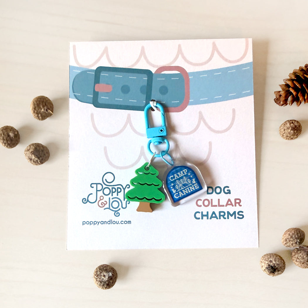 Dog Collar charm with an evergreen tree and a Camp Canine charm shown with the packaging.