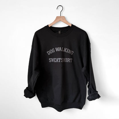 Black sweatshirt with 'Dog Walking Sweatshirt' text on a hanger against a white background