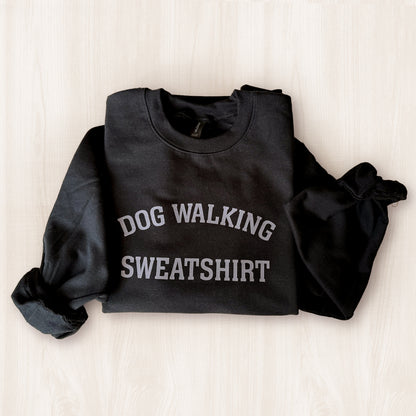 Black sweatshirt with 'DOG WALKING SWEATSHIRT' text on a light background