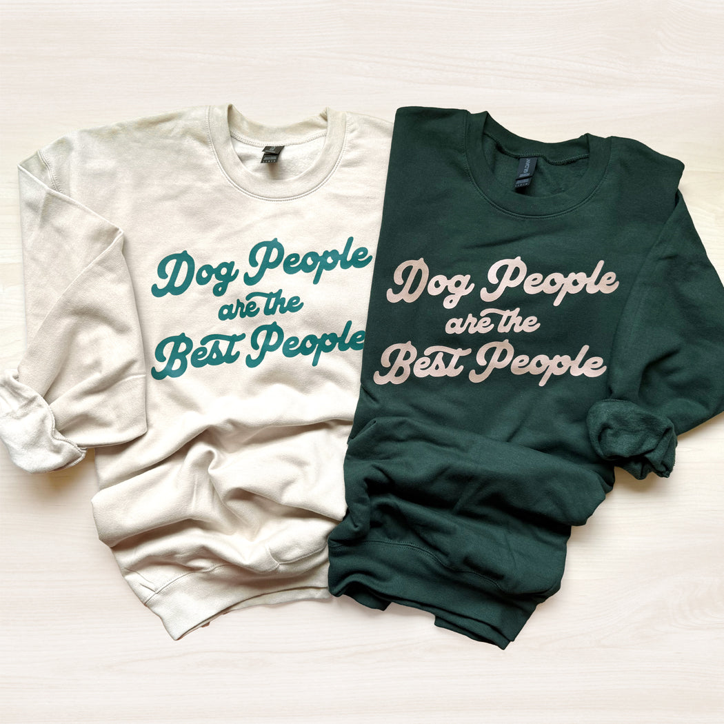 Two sweatshirts, one white and one green, with text 'Dog People are the Best People' on a light background.