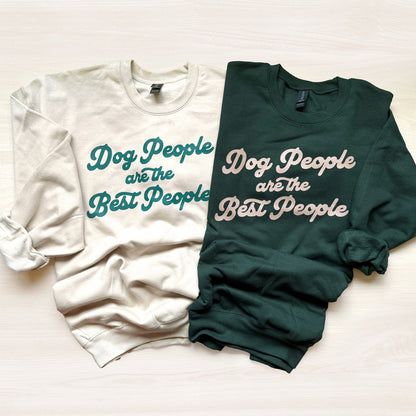 Two sweatshirts, one white and one green, with text 'Dog People are the Best People' on a light background.