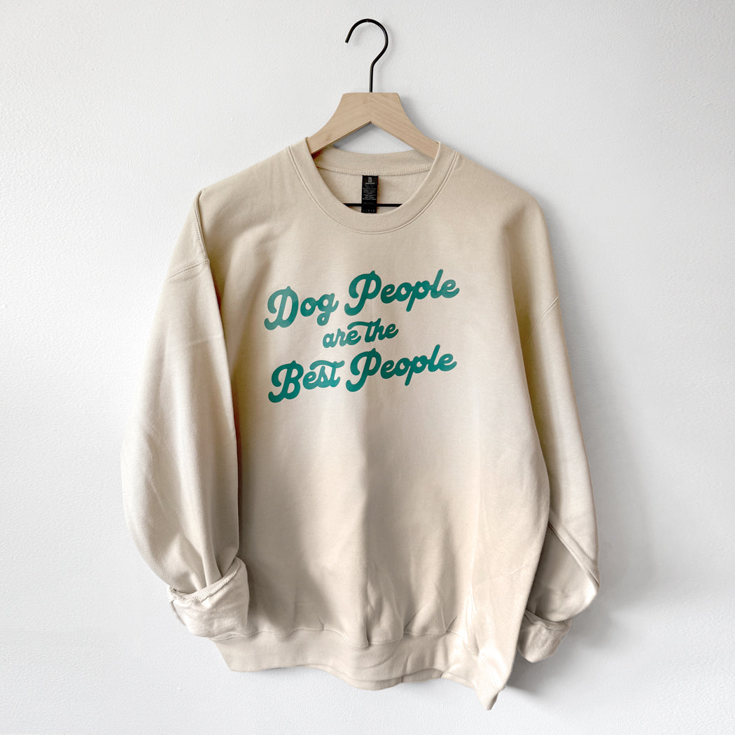 Beige sweatshirt with 'Dog People are the Best People' text on a hanger against a white background