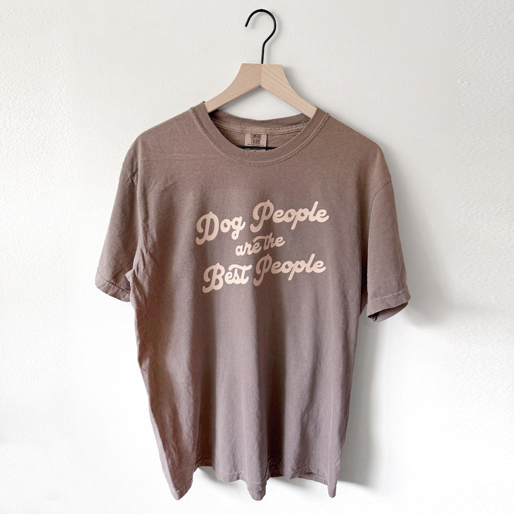 Brown t-shirt with 'Dog People are the Best People' text on a hanger against a white background
