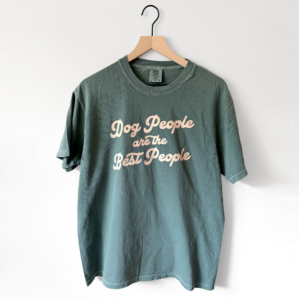 Teal t-shirt with 'Dog People are the Best People' text on a hanger against a white background