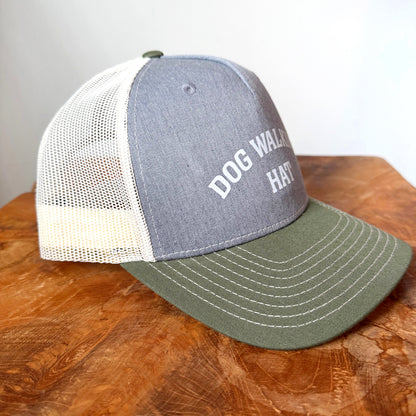 Close-up of Dog Walking Hat with gray front panel, forest green brim, and white text