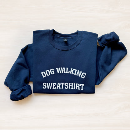 Navy blue sweatshirt with 'DOG WALKING SWEATSHIRT' text on a light background