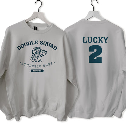 Gray sweatshirt with 'Doodle Squad' and 'Lucky 2' text on hangers against a white background