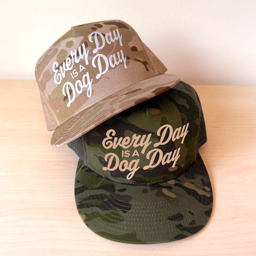 Every Day Is a Dog Day trucker hat in Multicam Tropic green camouflage and Multicam Arid Tan. Stacked on a light background.