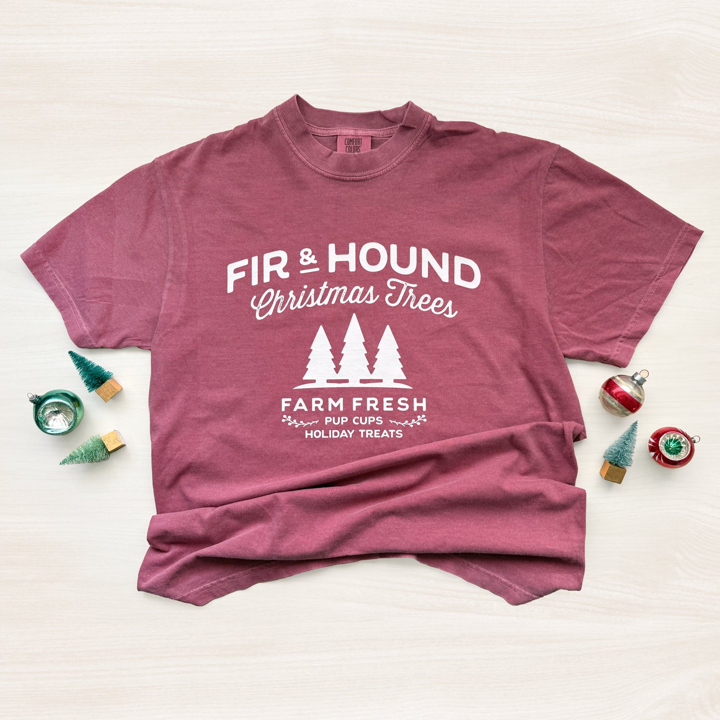 Maroon t-shirt with white text and graphics on a light background