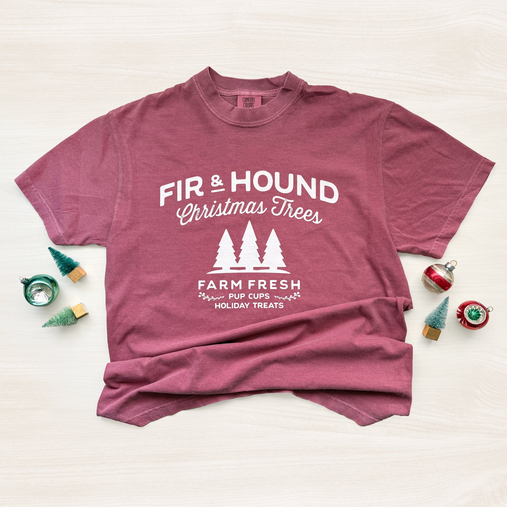 Maroon t-shirt with white text and graphics on a light background