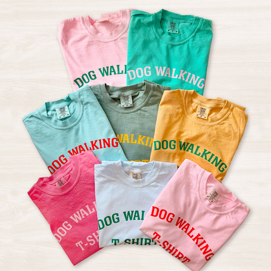 Collection of colorful t-shirts with 'DOG WALKING' text on a light background