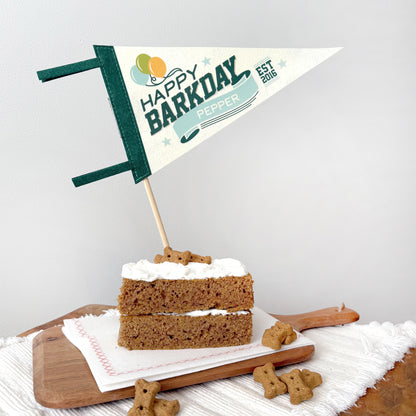 Dog birthday cake with 'Happy Barkday' flag on a wooden board