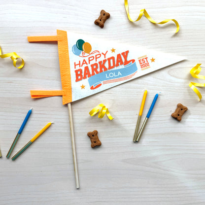 Dog birthday banner with candles and treats on a wooden surface