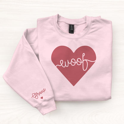 Pink sweatshirt with a red heart and 'woof' text on a white background