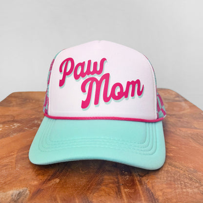 Trucker hat with 'Paw Mom' text on a wooden surface