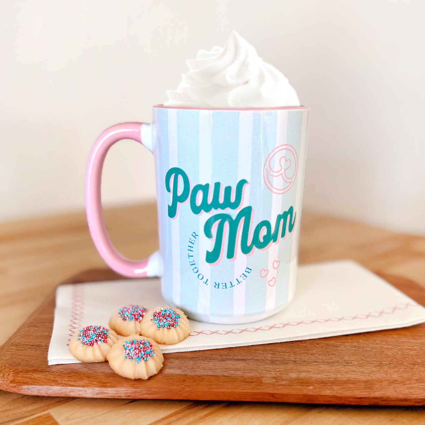 Mug with pink handle wtih retro style font that says "Paw Mom"