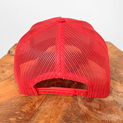 Red mesh cap on a wooden surface with a white background