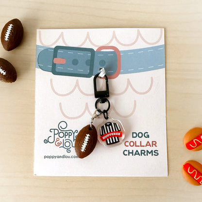 A dog collar charm set displayed on a branded card. The set includes a brown football-shaped charm, a black and white striped referee shirt charm with 'COFFEEHOUSE' written on it, and a black clip.