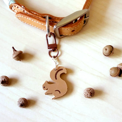 Squirrel dog collar charm attached to a tan leather dog collar with acorns, part of the Poppy & Lou Charm Collection.