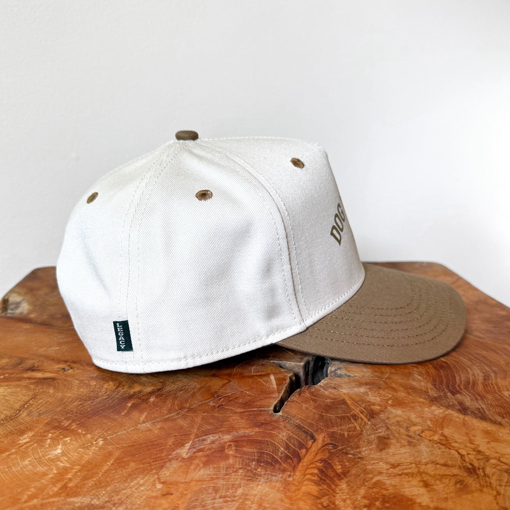 Two caps, one white and one brown, on a wooden surface with a white background.