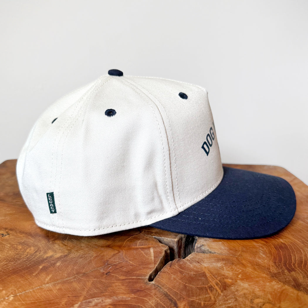 White and navy cap on a wooden surface with a white background