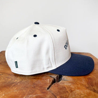 White and navy cap on a wooden surface with a white background