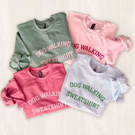 Four sweatshirts in different colors with 'DOG WALKING SWEATSHIRT' text on a light background