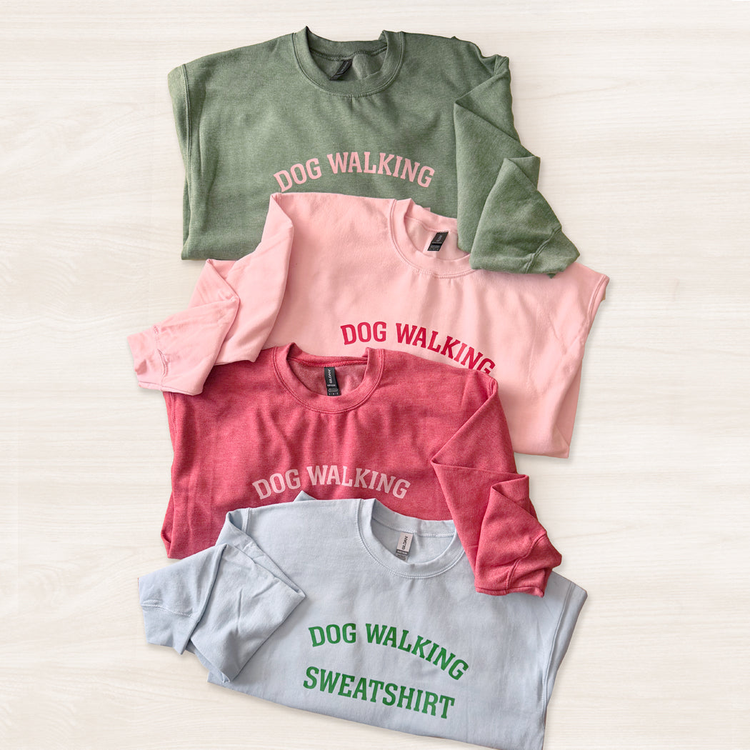 Three sweatshirts in green, pink, and gray with 'DOG WALKING' text on a light background