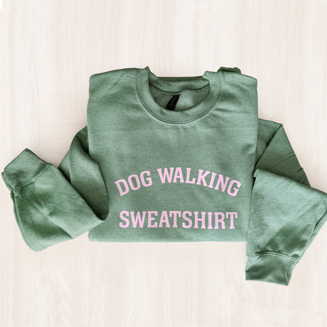 Green sweatshirt with 'DOG WALKING SWEATSHIRT' text in pink on a light background