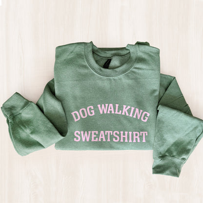 Green sweatshirt with 'DOG WALKING SWEATSHIRT' text in pink on a light background