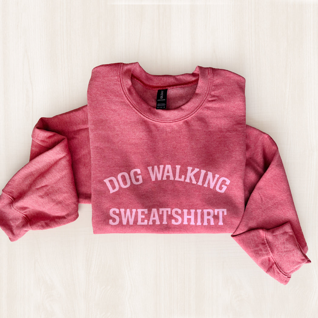 Pink sweatshirt with 'DOG WALKING SWEATSHIRT' text on a light background