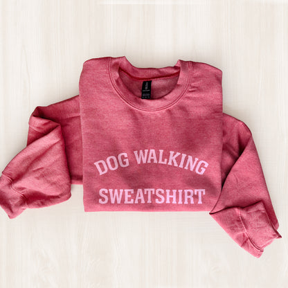 Pink sweatshirt with 'DOG WALKING SWEATSHIRT' text on a light background